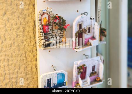 Blick auf traditionelle touristische Souvenirs und Geschenke aus Athen, Attika, Griechenland mit Kühlschrankmagneten mit Text „Griechenland“, „Athen“ und Schlüsselanhänger, in Stockfoto