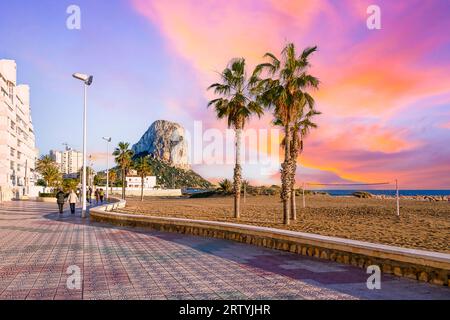 Calpe, Spanien - 10. Januar 2023: Touristen, die während des Sonnenuntergangs auf dem Strandboulevard spazieren Stockfoto