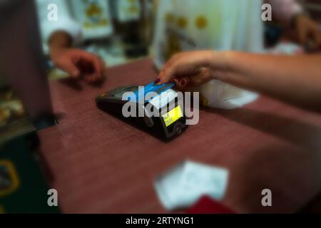 Kontaktloses Zahlungskonzept, Nahaufnahme der Hände des Verkäufers und Käufers bei bargeldlosen Transaktionen mit Debit-o-Kreditkarte in der Türkei in Lira Stockfoto