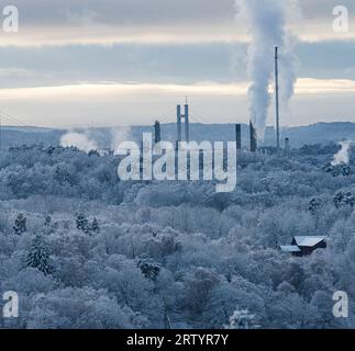 Hängebrücke und Industrie hinter einem eisigen Winterwald Stockfoto