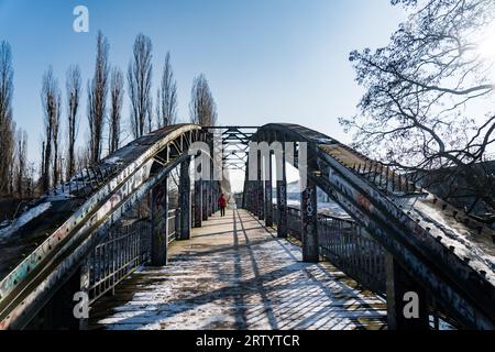 Mann, der im Winter auf einer Stahlbrücke läuft Stockfoto