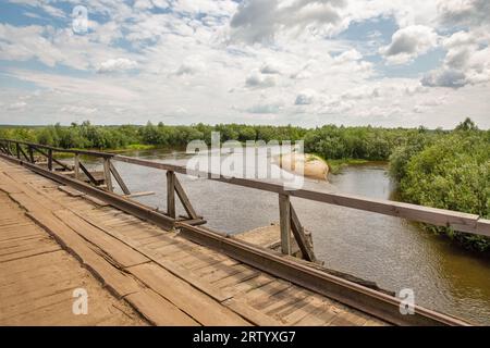 Alte Holzbrücke über den Fluss Sluch. Dorf Liukhcha in der Region Rivne, Ukraine. Stockfoto