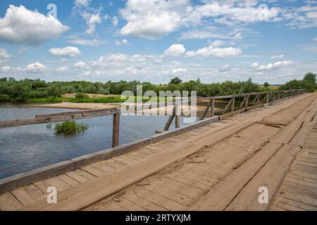 Alte Holzbrücke über den Fluss Sluch. Dorf Liukhcha in der Region Rivne, Ukraine. Stockfoto