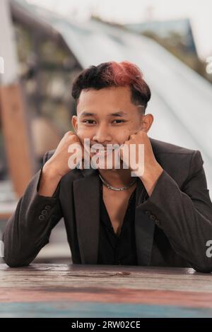 Ein Teenager mit blondem Haar posiert sehr lustig und niedlich, wenn er tagsüber einen Anzug trägt Stockfoto