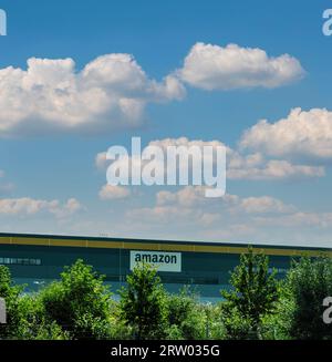London, Großbritannien - 14. September 2023: Das quadratische Bild unter klarem Himmel hebt ein großes Amazon-Lager hervor, dessen Fassade mit dem Firmenlogo verziert ist und das Paradigma des E-Commerce darstellt. Stockfoto