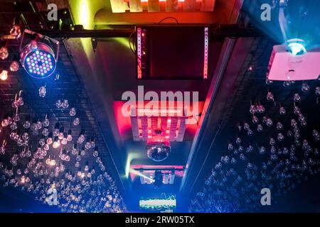 Ein Element des modernen Innenraums der Decke eines Nachtclubs mit Glühbirnen und einer Discokugel in Neonlicht. Stockfoto