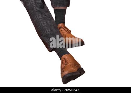 Männer Business-Kleidung Stil Füße in grauen karierten Hosen und braunen Stiefeln modisch auf weißem Hintergrund isoliert. Stockfoto