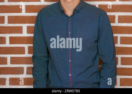 Männer Business-Stil Mode Skinny Guy Mode in blauem Hemd auf Backsteinwand Hintergrund. Stockfoto