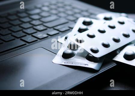 Antipyretika-Tabletten in Blisterpackungen auf einer Laptop-Tastatur mit selektivem Fokus Stockfoto