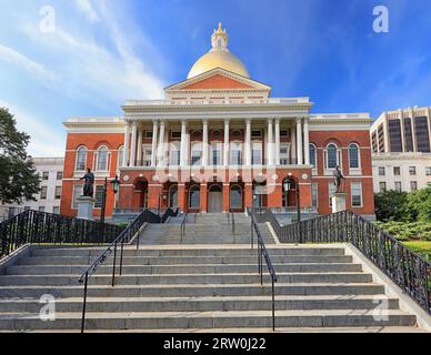 Massachusetts State House und State Library. Imposantes rotes Gebäude mit weißen Säulen und goldener Kuppel. Stockfoto