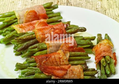 Bohnen- und Schinkenrolle auf weißem Teller Stockfoto