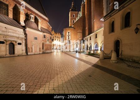 Mariacki-Platz bei Nacht in der Altstadt von Krakau in Polen. Neben der Marienkirche (auf der rechten Seite) Stockfoto