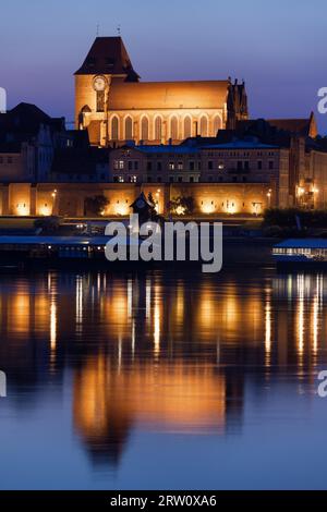 Altstadt von Torun in Polen, Reflexion über das Wasser der Weichsel, beleuchtete Kathedrale Basilika St. Johannes der Täufer und St. Johannes der Evangelist Stockfoto