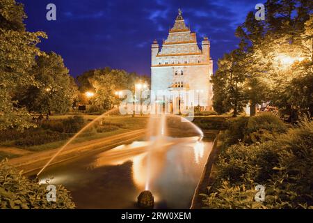 Park mit Brunnen bei Nacht in Torun, Polen und Collegium Maximum der Nicolaus Copernicus Universität Stockfoto