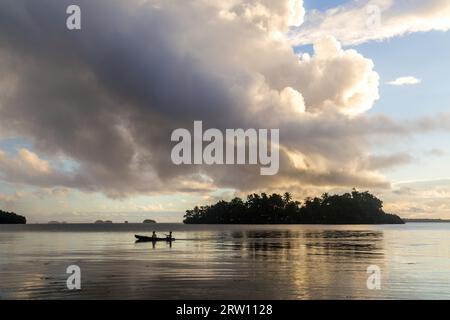 Marovo Lagoon, Salomonen, 5. Juni 2015: Kinder auf dem Weg zur Schule mit einem Kanu bei Sonnenaufgang Stockfoto