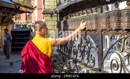 Swayambunath, Nepal, 20. Oktober 2014: Ein buddhistischer Mönch, der das Gebetsrad im Swayambunath-Tempel dreht Stockfoto