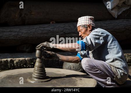 Bhaktapur, Nepal, 5. Dezember 2014: Ein nepalesischer Mann, der einen Topf auf einem Töpferrad auf dem Töpferplatz macht Stockfoto