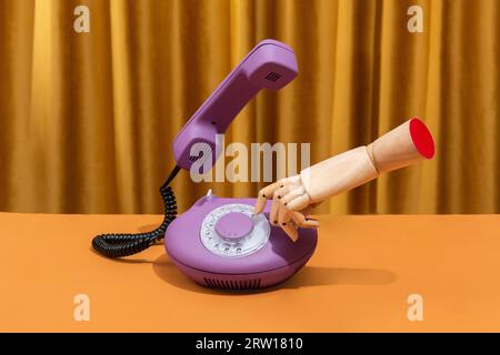 Holzhand wählt eine Nummer auf einem Retro-Telefon. Konzeptionelles Foto. Hochwertige Fotos Stockfoto