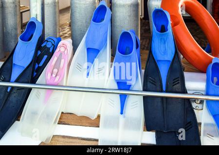 Bunte Gummiflossen zum Schwimmen im Meer werden an Bord der Yacht getrocknet. Urlaub, Abenteuer, Tauchen. Nahaufnahme. Selektiver Fokus. Stockfoto