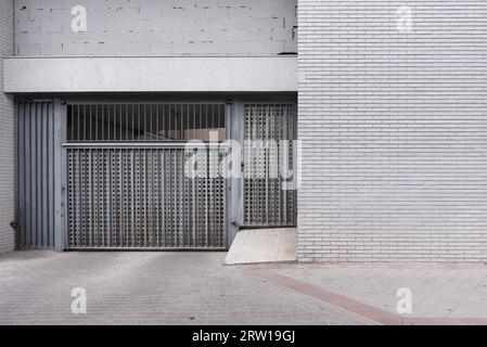 Graues Metallportal für den Zugang zu einem Haus neben dem Portal eines Fahrzeugzugangs Stockfoto