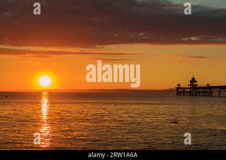 Clevedon Pier an einem hellen und farbenfrohen Abend, während die Sonne über der walisischen Küste untergeht Stockfoto