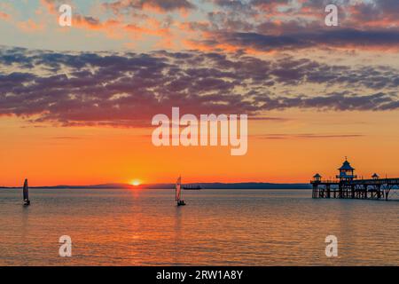 Clevedon Pier an einem hellen und farbenfrohen Abend, während die Sonne über der walisischen Küste untergeht Stockfoto