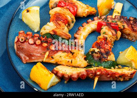 Leckere Meeresfrüchte Oktopus Tentakel Spieße auf blauem Teller. Stockfoto