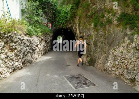 Eine sportliche Frau, die durch einen Tunnel auf dem Felsen von Gibraltar trainiert Stockfoto