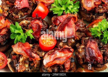 Champignon portobello Pilzkappen gefüllt mit Hackfleisch, Tomaten und Speck. Nahaufnahme. Stockfoto