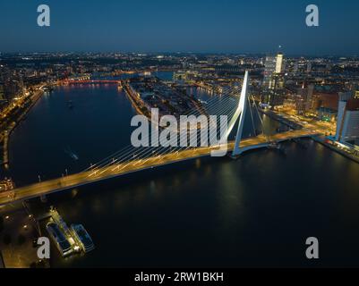 Berühmte Erasmusbridge in Rotterdam, Transport über den Nieuwe Maas Fluss in der Stadt bei Nacht. Stadtbild und Blick auf die Skyline. Stockfoto