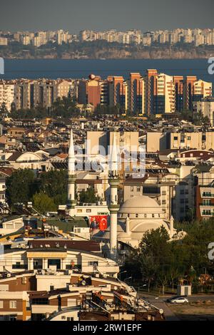 28.10.2022, Türkei, Antalya, Antalya - Blick von Westen über die Metropole in Richtung Stadtzentrum (am Horizont), vor einer Moschee. 00A221028D1 Stockfoto