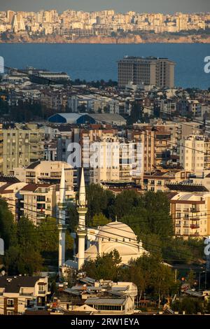 28.10.2022, Türkei, Antalya, Antalya - Blick von Westen über die Metropole in Richtung Stadtzentrum (am Horizont), vor einer Moschee. 00A221028D1 Stockfoto