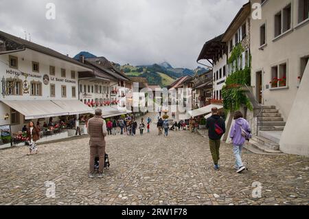 GRUYERES, SCHWEIZ - 6. AUGUST 2023: Menschen in der mittelalterlichen Stadt Gruyeres, Freiburg Stockfoto