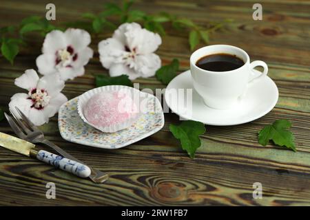 Bunte japanische Süßigkeiten wie Daifuku oder Mochi. Süßigkeiten auf dem Teller mit einer Tasse Kaffee Stockfoto