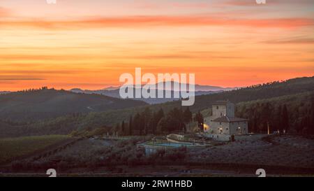 Toskanischer Chianti Sonnenuntergang mit Blick auf ein Cottage, Zypressen und Rolling Hills Stockfoto