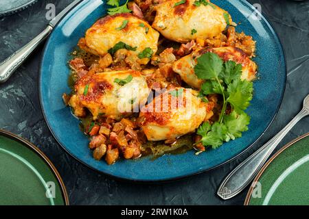 Gebratener gefüllter Tintenfisch oder Calamari mit Salsa-Sauce auf einem Teller. Stockfoto