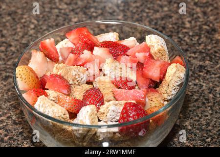 Nahaufnahme von Weizenkerealien mit gehackten Erdbeeren. Stockfoto