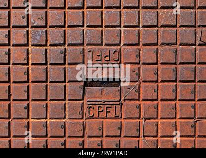 RIBEIRAO PRETO, SAO PAULO, BRASILIEN - 19. April 2023: Metallische rostige Oberfläche, Inspektionsabdeckung von CPFL (Companhia Paulistana de Forcae Luz) Stockfoto