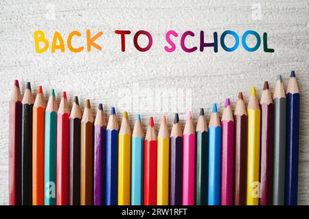 Bunte Bleistiftstifte auf weißem Marmorhintergrund, Back-to-School-Text mit bunten Bleistiftkreiden. Stockfoto