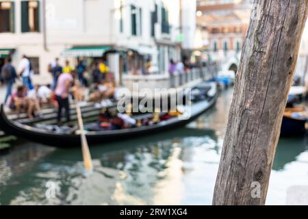 Verschwommener malerischer Blick auf einen Kanal in Venedig, Italien mit Gondel und dem berühmten rot gestreiften Hemd Gondolier, Venedig, Stockfoto
