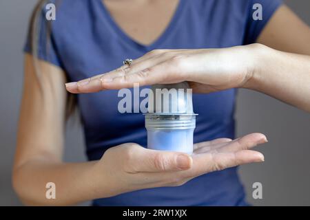 Nahaufnahme eines Mädchens, das vor dem Aufkleben auf den Arm den Halter für das Flash-Glucose-Monitoring-Pflaster hält Stockfoto