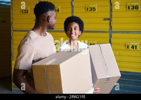 Afroamerikanische Jungs im Lager mit Kartons in den Händen Stockfoto
