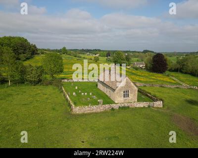 Eine Luftaufnahme der St. Oswald's Church Widford in einem üppigen Grün unter dem blauen Himmel Stockfoto