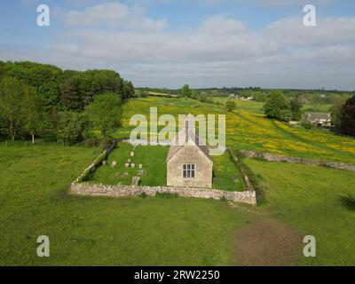 Eine Luftaufnahme der St. Oswald's Church Widford in einem üppigen Grün unter dem blauen Himmel Stockfoto