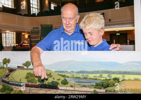 Troon, Großbritannien. September 2023. Die Ayr Model Railway Group veranstaltete ihre jährliche Modelleisenbahnausstellung in Troon, Schottland, Großbritannien, mit Exponaten und Sets, die von Einzelpersonen und anderen Modellclubs aus ganz Schottland gebaut wurden. Bild von David Waller und seinem Enkel Angus Waller mit Blick auf das Greenock and District Railway Club 'N' Spurmodell der Lammermoor Railway. Quelle: Findlay/Alamy Live News Stockfoto