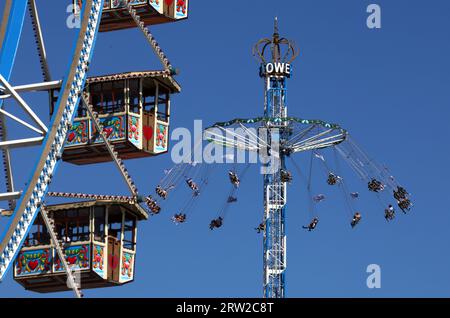 München, Deutschland. September 2023. Besucher des Oktoberfests reiten auf dem Kettenkarussell hinter dem Riesenrad. Die 188. Wiesn findet in diesem Jahr vom 16.09.-03.10.2023. Statt. Quelle: Karl-Josef Hildenbrand/dpa/Alamy Live News Stockfoto