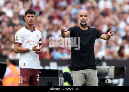 Manchester City Manager PEP Guardiola und Matheus Nunes auf der Touchline während des Premier League Spiels im London Stadium, London. Bilddatum: Samstag, 16. September 2023. Stockfoto