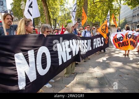 London, England, Großbritannien 16. September 2023 Demonstranten aus einer Koalition von Bewegungen marschieren gegen fossile Brennstoffe in einer gemeinsamen britischen Aktion mit Protesten in mehr als 60 Ländern. Zu den Demonstranten gesellten sich die roten Rebellen, und eine Theateraktion, in der Kier Starmer die großen Ölkonzerne unterhielt, die gefälschtes Öl aus einer Champagnerflasche in Champagnergläser gossen, wurde abgehalten. Quelle: Denise Laura Baker/Alamy Live News Stockfoto