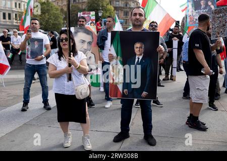 London, Großbritannien. September 2023. Iranische Demonstranten werden während der Demonstration zum Gedenken an den Tod von Mahsa Amini unter der Regierung der Islamischen Republik Iran mit einem Porträt von Reza Pahlavi, Kronprinz von Iran, gesehen. Iraner und ihre Unterstützer versammelten sich auf dem Trafalgar-Platz, um eines Jahres des Todes von Mahsa Amini zu gedenken, einer 22-jährigen iranischen Frau, die wenige Tage nach ihrer Verhaftung durch die religiöse Polizei starb, weil sie angeblich gegen die strenge Kleiderordnung verstoßen hatte (ohne den Hijab zu tragen). Quelle: SOPA Images Limited/Alamy Live News Stockfoto