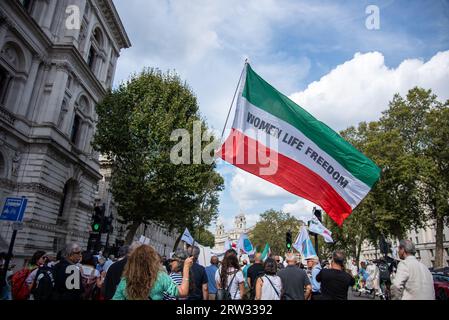 London, Großbritannien. September 2023. Ein Demonstrant hält eine große iranische Flagge, die während der Mahsa Amini Day - Woman Life Freedom Rally auf „Women Life Freedom“ steht. Iraner und nicht-Iraner schlossen sich dem demokratiemarsch an. Am Jahrestag des Todes von Mahsa Amini fanden in allen Städten der Welt globale Kundgebungen statt, um Solidarität mit dem iranischen Volk zu zeigen, das unter enormer Unterdrückung und Ungerechtigkeit durch das Regime der Islamischen Republik und ihre Sicherheitskräfte leidet. das Korps der Iranischen Islamischen Revolutionsgarde (IRGC). Quelle: SOPA Images Limited/Alamy Live News Stockfoto